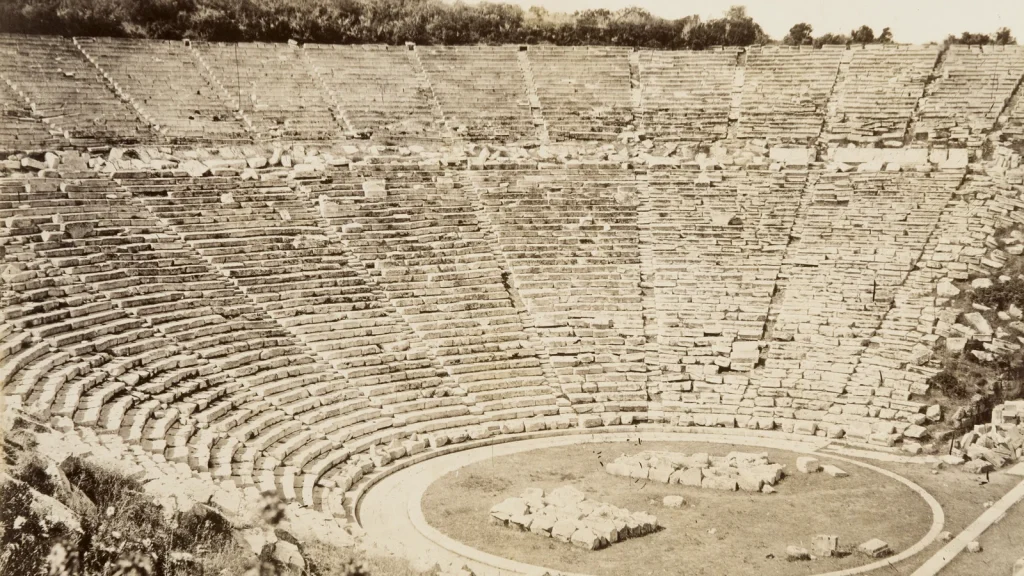 Sepia 1896 photograph of the ancient theatre in the Sanctuary of Asclepius at Epidaurus, its curved stone seats rising above the round orchestra, from the Hallwyl Museum, Stockholm